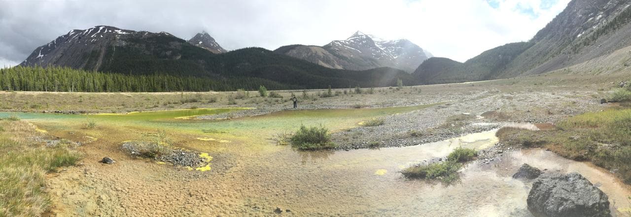 Braided outwash flats and shallow pools below a glaciated mountain valley